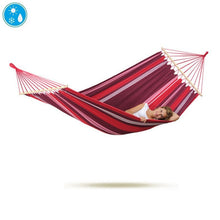 Load image into Gallery viewer, A single Aruba Fuego hammock in pink and red colours, with a person lying comfortably on it.