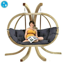Load image into Gallery viewer, A person sitting on a Globo Royal Double Hanging Egg Chair set with a grey cushion, indoors.