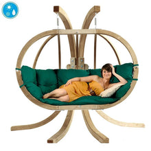 Load image into Gallery viewer, A person sitting on a Globo Royal Double Hanging Egg Chair set with a grey cushion, indoors.